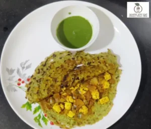 Protein-packed moong dal cheela plate with paneer toppings and green dip.