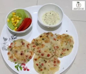 Uttapam plate with 4 small sized Uttapas and some salad slices
