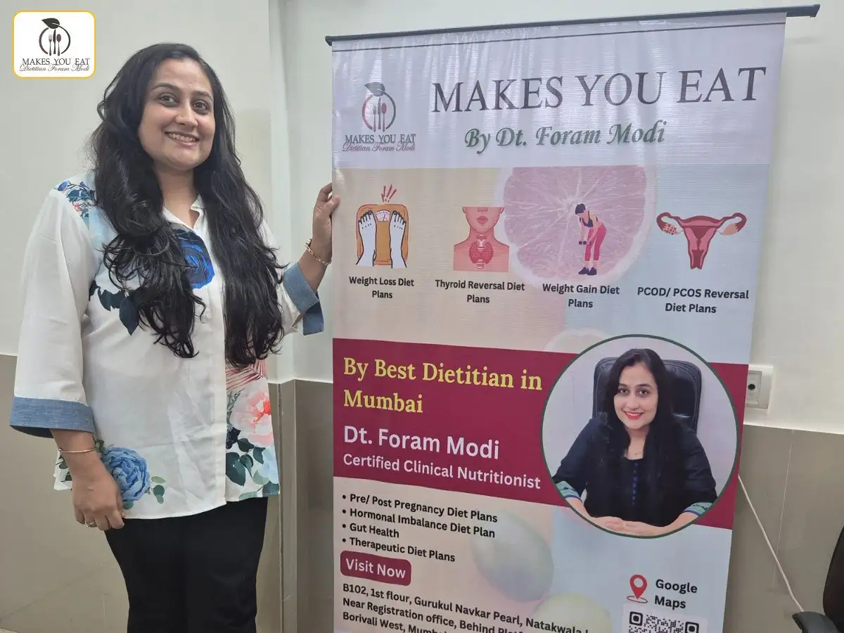 Dt. Foram Modi with marketing standee at the clinic in Mumbai, India.