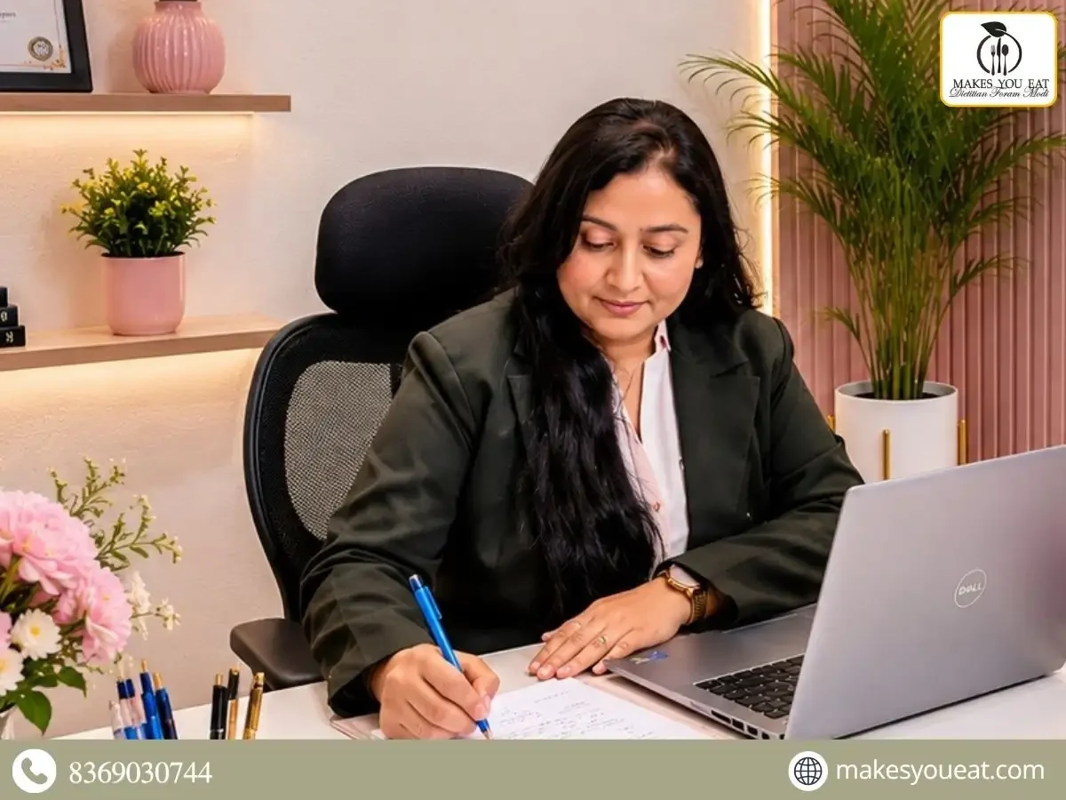 Dt. Foram Modi writing at her desk in office.