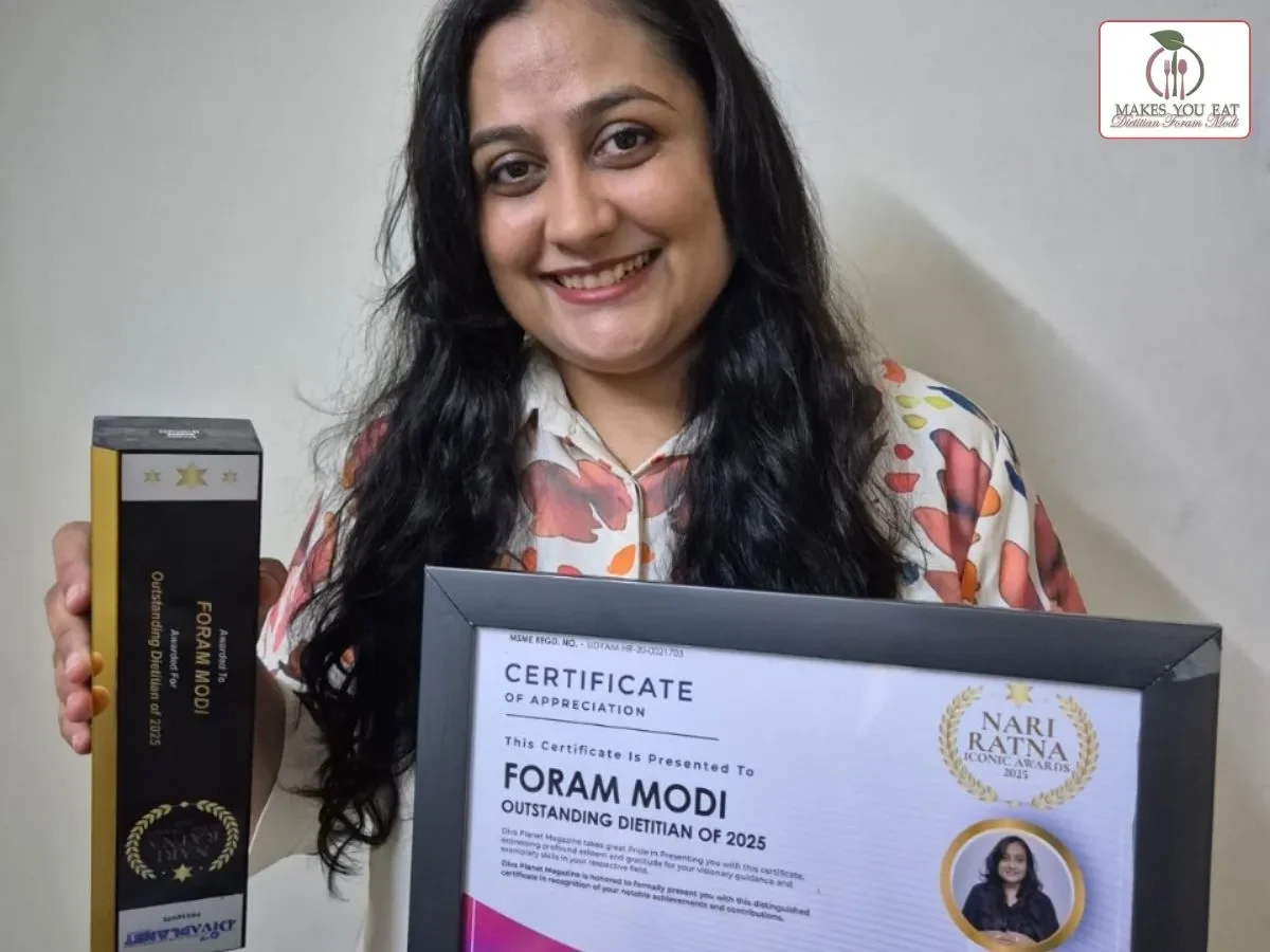 Dt. Foram Modi holding award trophy and certificate.