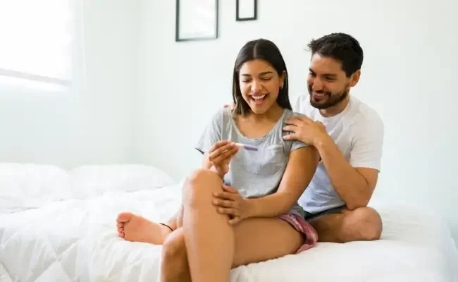 Indian couple looking at pregnancy test result.