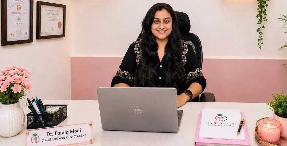 Dt. Foram Modi at her diet clinic with laptop on table.
