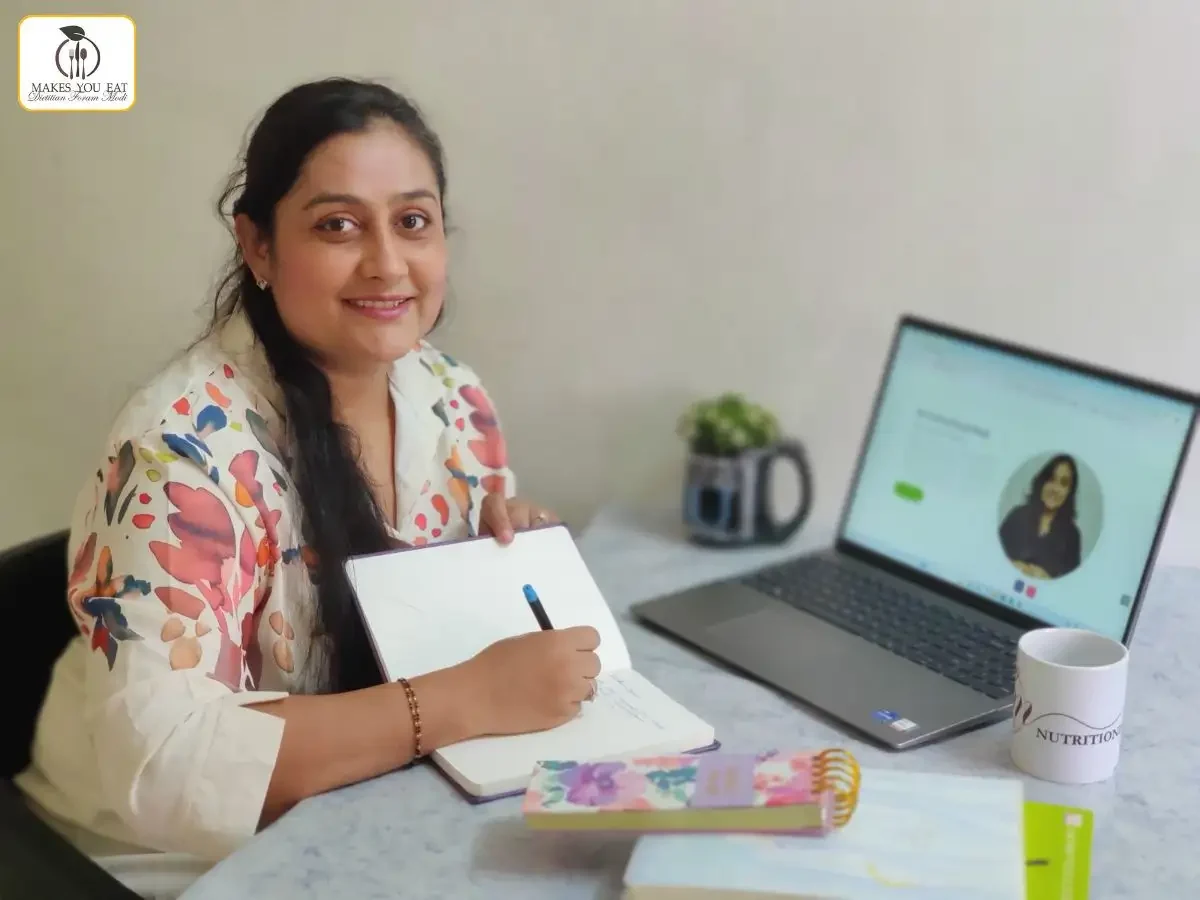 Dt. Foram Modi with her laptop and notebook.