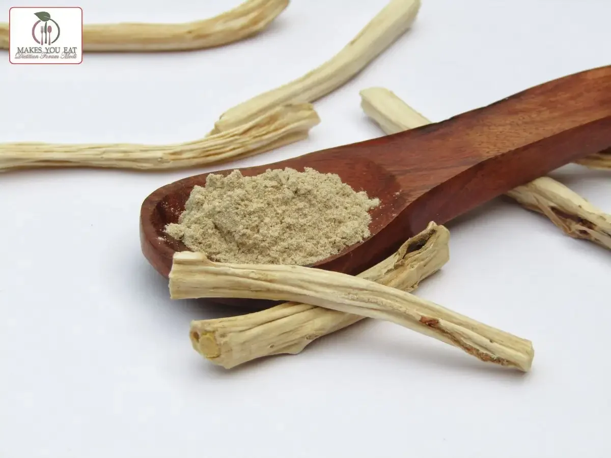 Shatavari powder in a spoon with sticks beside.