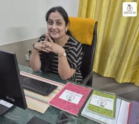Gut Dietitian Foram Modi sitting at her desk in diet clinic.