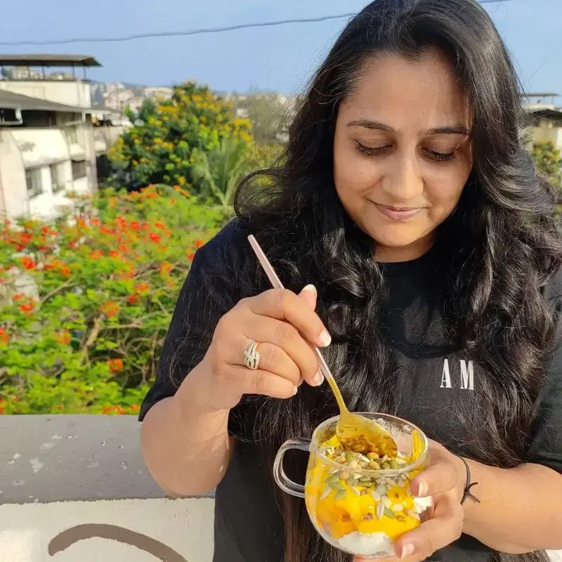 Dt. Foram Modi eating smoothie on a sunny day.